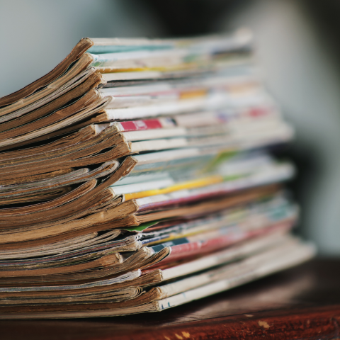 A close-up photograph of a stack of magazine spines. 