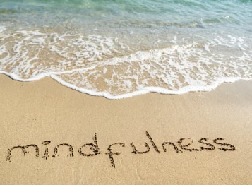 beach with mindfulness written in the sand