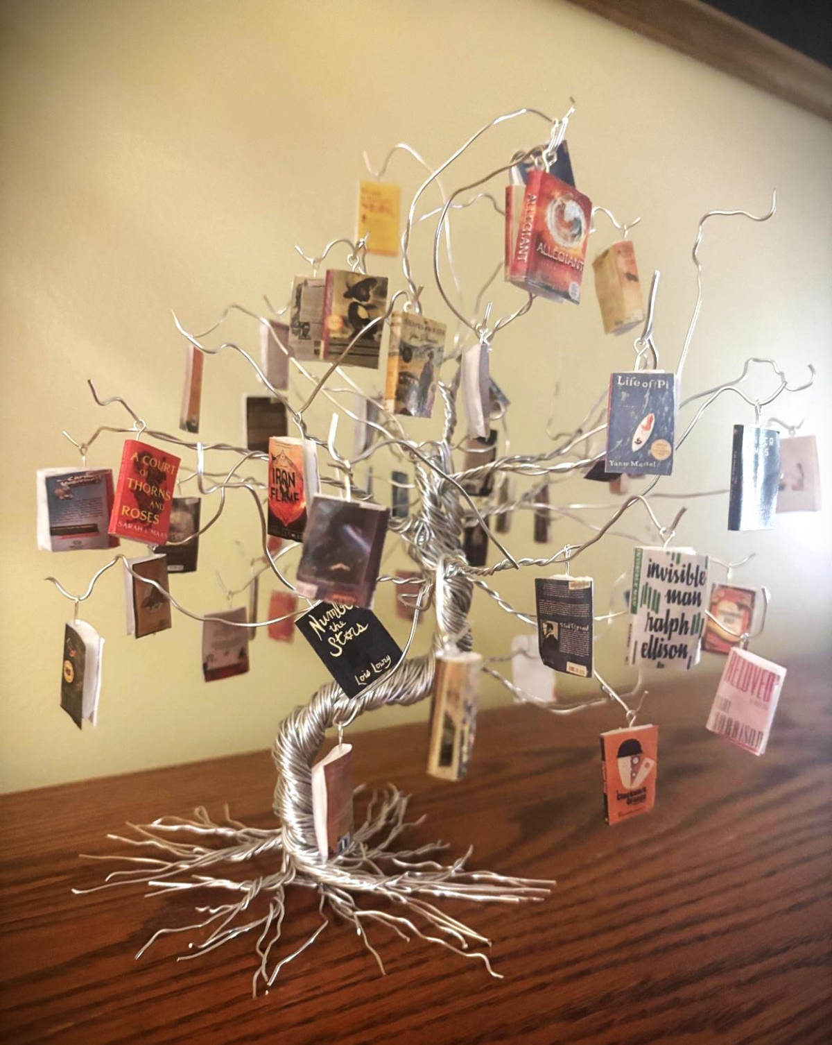 a wire tree with mini banned books hanging on it